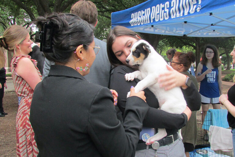 HASS Government Communications Guide - Women chatting and holding a puppy at an Austin Pets Alive! policy event