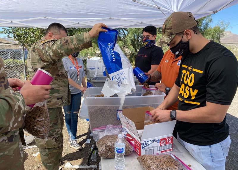 Volunteers filling bags of pet food.